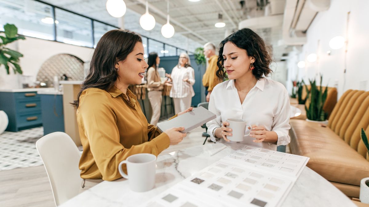 Due donne discutono di progetti professionali in un ambiente moderno e luminoso.